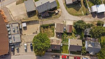 Vue aérienne d’un quartier résidentiel avec des maisons, un parking et un petit immeuble commercial.