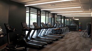 Een sportschool met loopbanden, hometrainers en gewichten.