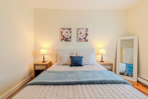 A bedroom with a bed, two bedside tables, a mirror, and two wall-mounted floral paintings. - NEW - Boston/Cambridge/3BR/Near MIT + Newbury St (Cambridge)