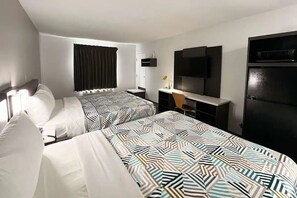 Ein Hotelzimmer mit zwei Betten, einem Schreibtisch, einem Fernseher und einem Kleiderschrank.