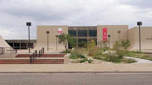 A modern building with a flat roof, a large entrance with steps, and a sign indicating a 90% discount. - Enjoy a Convenient Kitchen-Equipped Stay for Longer Comfort | Free Parking (Lubbock)