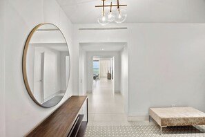 A modern hotel hallway with a round mirror, a bench, a bed, and a view to the outside. - Amazing Four Seasons Beachfront 4BR Residence - Golf Cart Included (Río Grande)