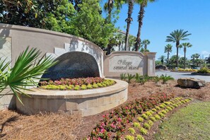A landscaped area with a sign reading 'Crystal Beach Villas.' - Luna Del Mar - Beach Oasis Home - Pool/Relax/Grill (Destin)
