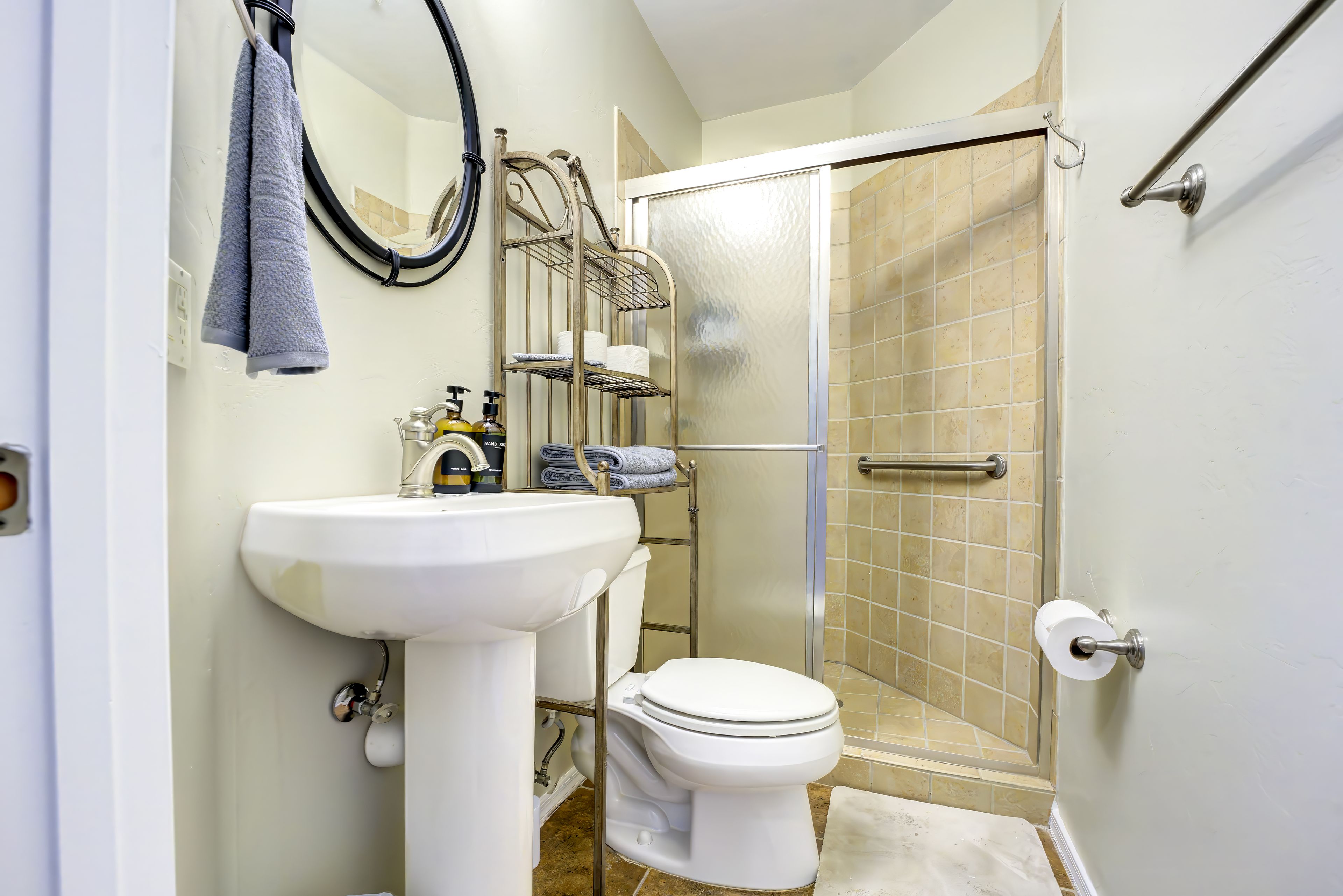 A bathroom with a white sink, toilet, and a glass shower enclosure.