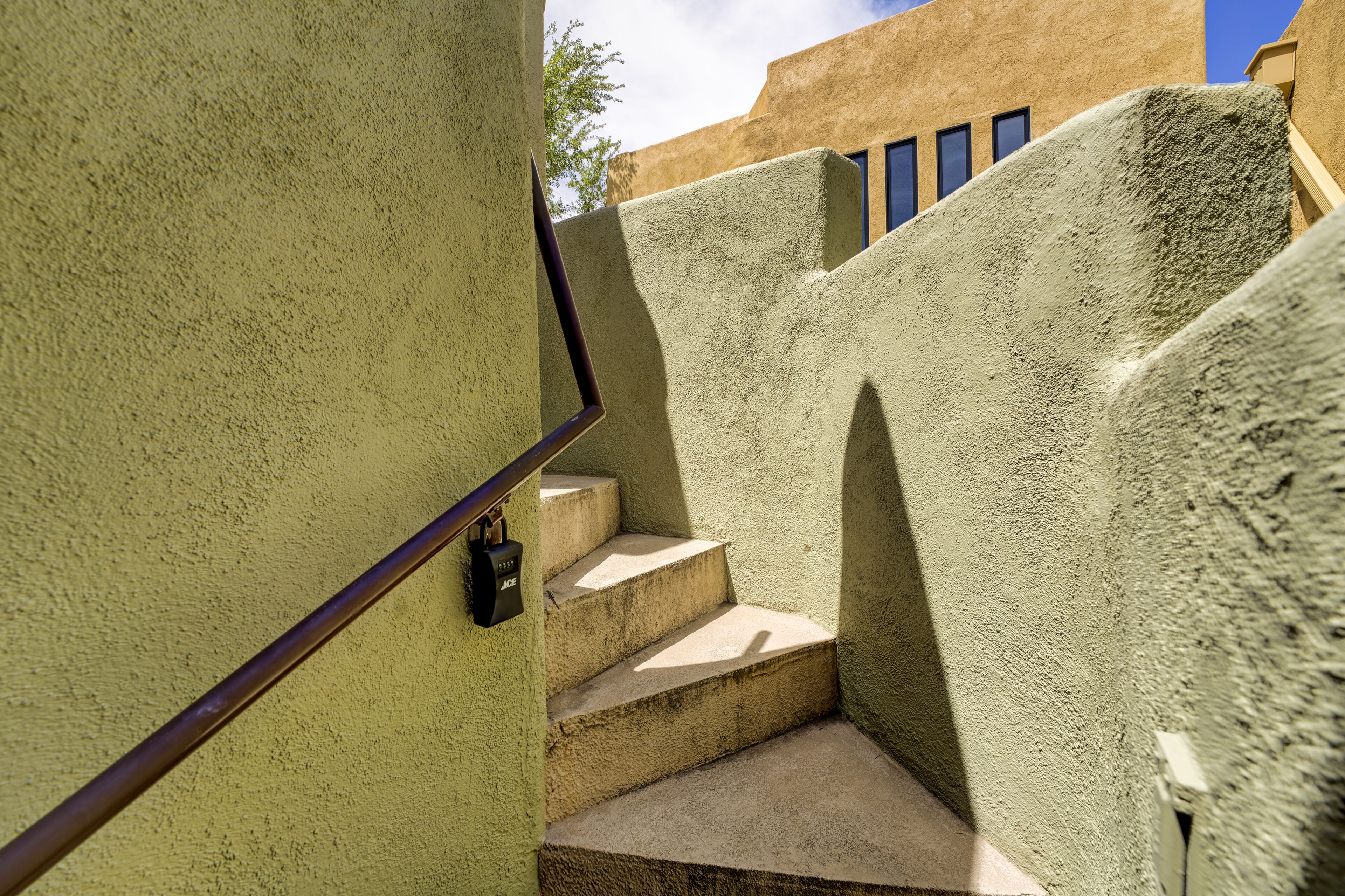 Eine Betontreppe mit Metallgeländer und einem Vorhängeschloss.