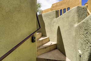 Una escalera de concreto con barandilla metálica y un candado.