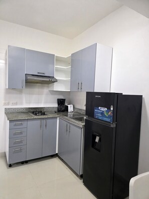 A kitchen with grey cabinets, a black refrigerator, a coffee maker, and a toaster. - Corales Ducassi Rooftop pool & tropical Caribbean sun (Punta Cana)