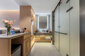 Un baño moderno con tocador, espejo y toallero.