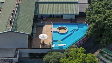 Vista aérea de un hotel con piscina, una tumbona y un pequeño jacuzzi.