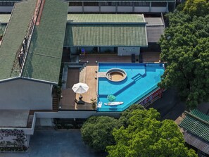 Vista aérea de un hotel con piscina, una tumbona y un pequeño jacuzzi.