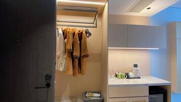 Un baño moderno con toallero, lavabo con artículos de aseo y armario.