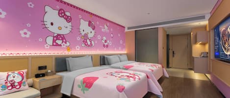 Una habitación de hotel con una pared temática rosa de Hello Kitty, dos camas con ropa de cama a juego, una mesita de noche con lámpara y un televisor en la pared.