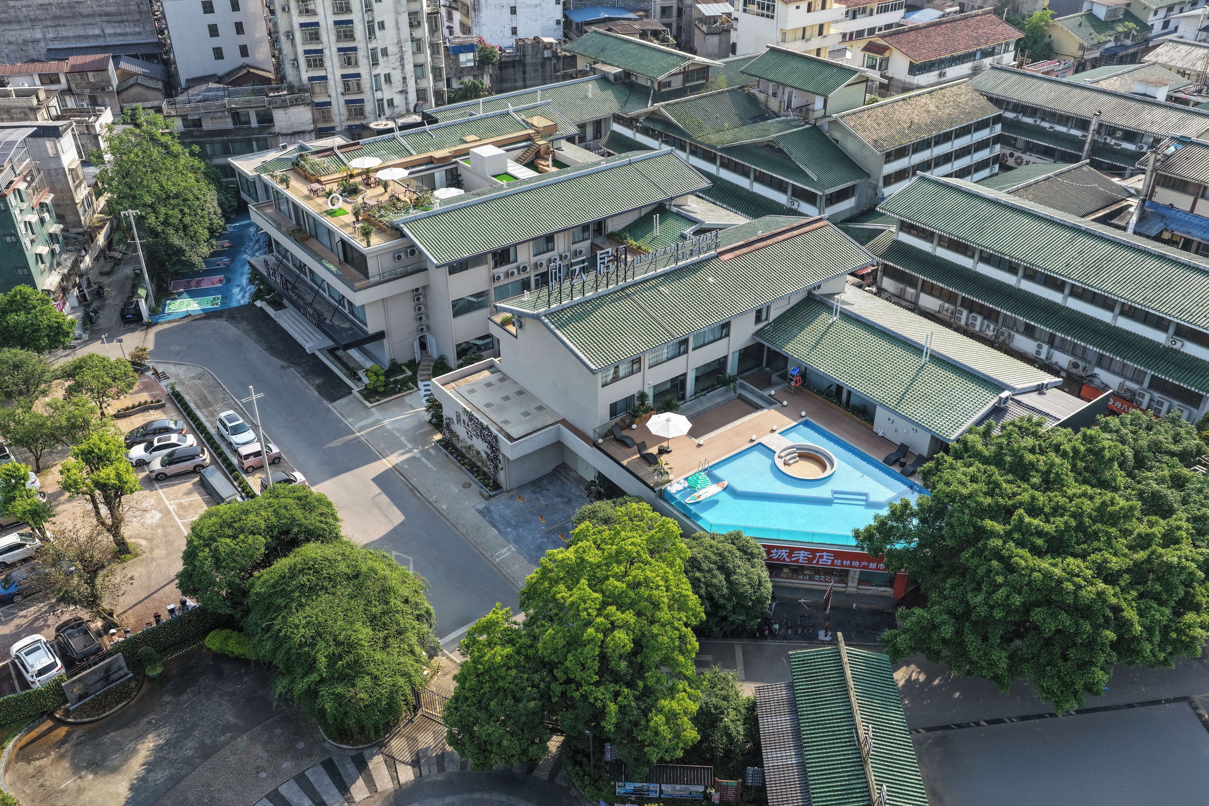 A multi-story building with a rooftop pool and a covered outdoor area.