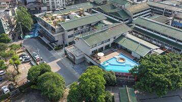 A multi-story building with a rooftop pool and a covered outdoor area.