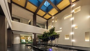 A spacious atrium with a central water feature, a skylight, and modern lighting. - Ting Ran Yun Ju Hotel Guilin (Nanjing)