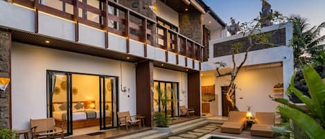 Un bâtiment moderne à deux étages, doté d’une piscine, d’un espace extérieur aménagé et d’un intérieur bien éclairé.