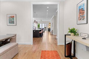 A modern interior with a kitchen area, dining space, and a hallway leading to a living area. - NEW Luxe 7BR Sleeps 20 - Hot Tub - 13 Min Downtown (Atlanta)