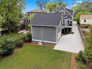 A residential property with a covered patio, a fenced yard, and a two-story house. - NEW Luxe 7BR Sleeps 20 - Hot Tub - 13 Min Downtown (Atlanta)