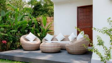 A garden with wicker furniture and a wooden door.