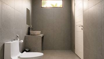 Un baño moderno con inodoro, lavamanos y ventana.