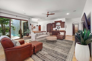 A spacious living room with a large sofa, a coffee table, and a ceiling fan. - 5 BR Villa + Private Pickleball & Pool +Views (Cabo San Lucas)
