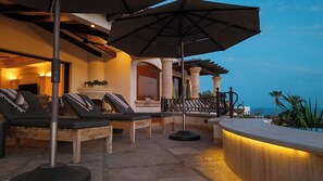 A patio with lounge chairs, a fireplace, and a view of the ocean. - 5 BR Villa + Private Pickleball & Pool +Views (Cabo San Lucas)