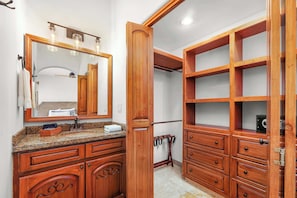A bathroom with a wooden vanity, a large mirror, and a built-in shelving unit. - 5 BR Villa + Private Pickleball & Pool +Views (Cabo San Lucas)