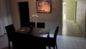 A dining area with a table, chairs, a vase with flowers, and a framed picture on the wall. - Fantastic 2-bedroom house with AC in charming Río Blanco (Río Blanco)