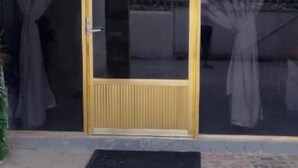 A building entrance with a glass door and a metal gate. - Fantastic 2-bedroom house with AC in charming Río Blanco (Río Blanco)