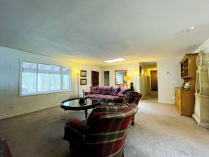 A living room with a couch, a coffee table, and a fireplace. - Legacy Homestead Cabin, White Mountains AZ (Navajo County)