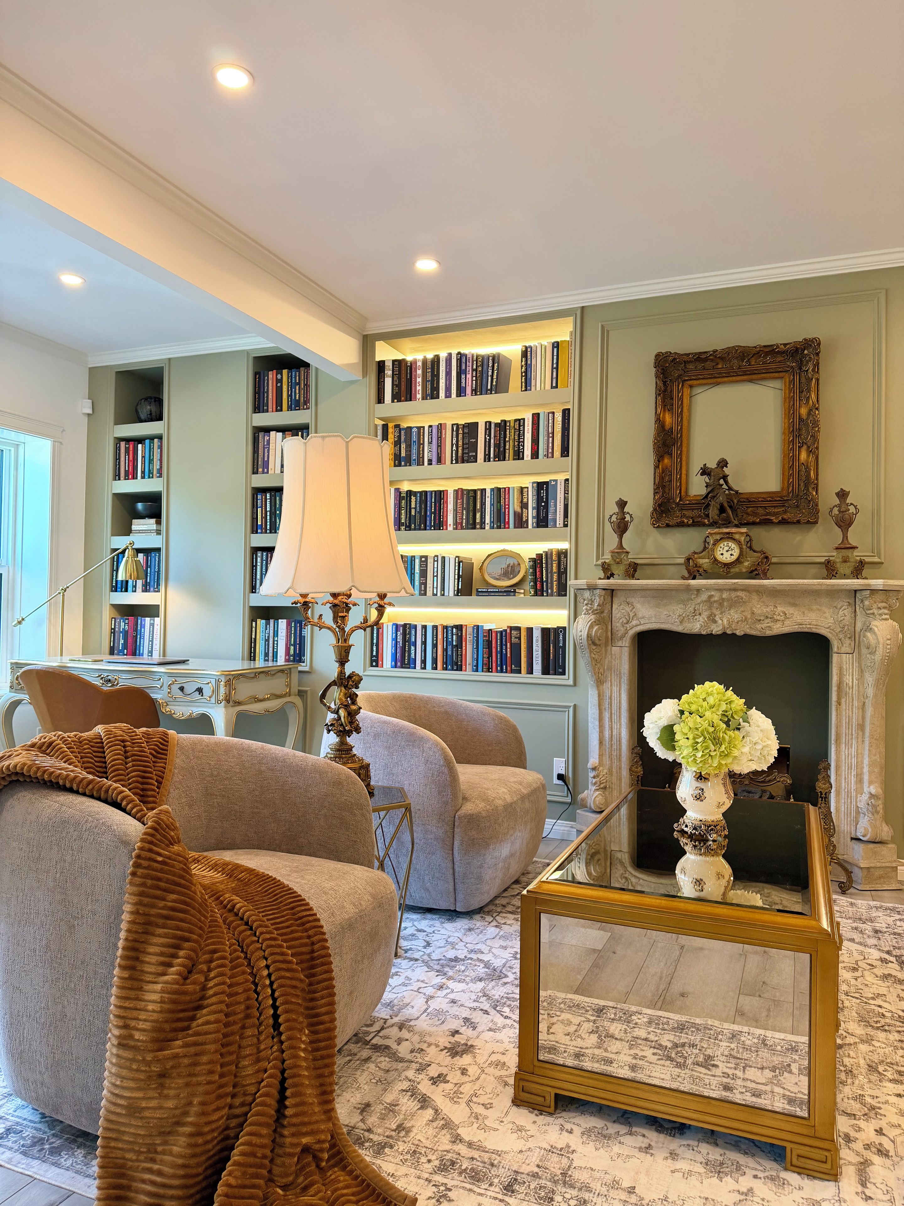 A living room with a fireplace, bookshelves, a coffee table, and a sofa.
