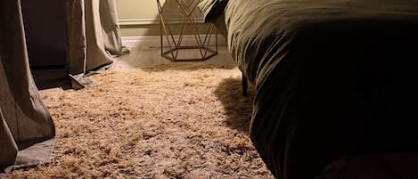 A bedroom with a bed, a nightstand, a lamp, and a candelabra.
