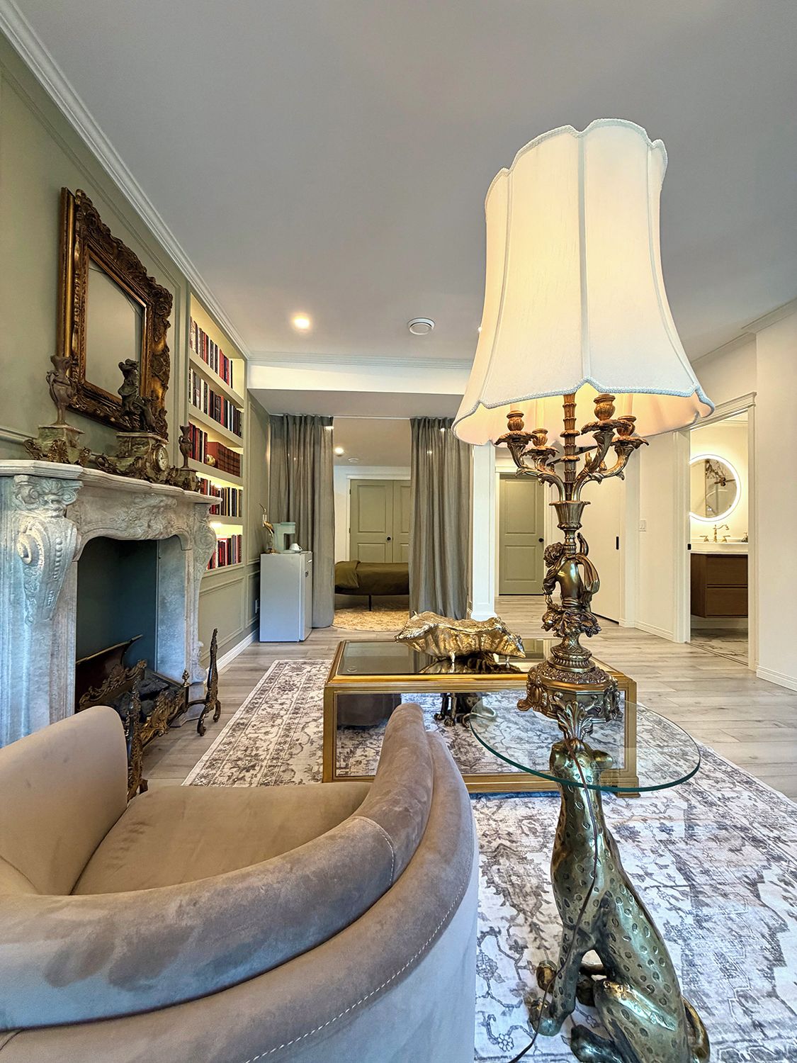 A living room with a fireplace, a sofa, a coffee table, and a decorative lamp.