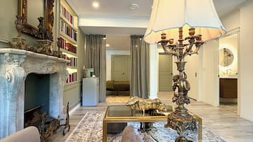A living room with a fireplace, a sofa, a coffee table, and a decorative lamp.