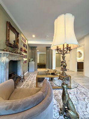 A living room with a fireplace, a sofa, a coffee table, and a decorative lamp.