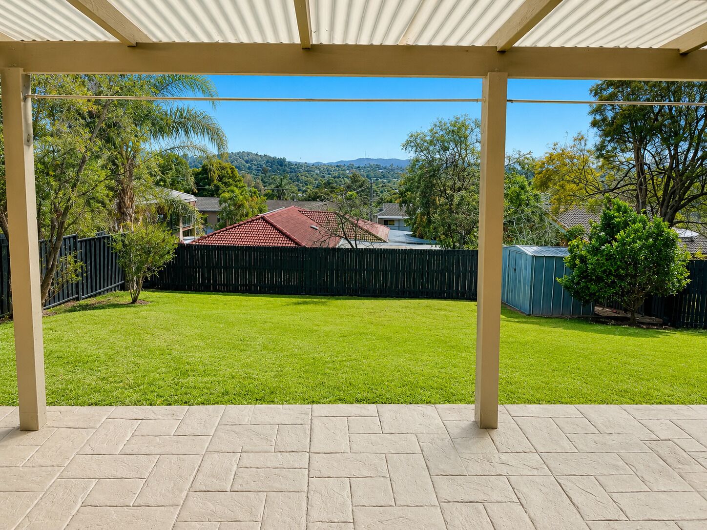 A covered patio area with a view of a backyard.