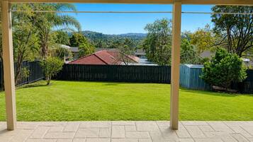 A covered patio area with a view of a backyard.