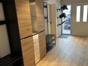 Ein Zimmer mit einem Holzschrank, einer Klimmzugstange und einer Bank.