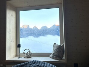 A room with a large window overlooking a mountainous landscape. - Chalet Waldhüsli (CharmingStay), (Flumserberg Tannenboden), by Interhome (Flumserberg Tannenheim)