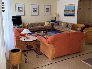 A living room with a sofa, armchairs, a coffee table, and a television. - Waldhaus Panorama Home (CharmingStay), (Flumserberg Tannenbodenalp), by Interhome (Flumserberg Tannenbodenalp)
