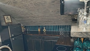 Una cocina con armarios de madera oscura, un lavamanos de acero inoxidable y una estufa negra.