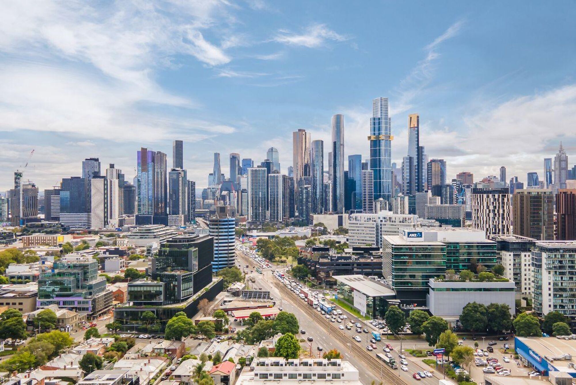A cityscape with modern high-rise buildings, a busy street, and a mix of commercial and residential structures.