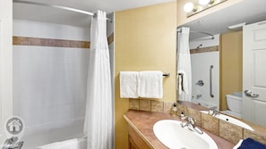Une salle de bain avec une douche, un lavabo et un miroir.