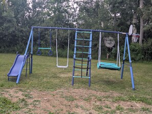 A playground with swings, a slide, and a climbing structure.