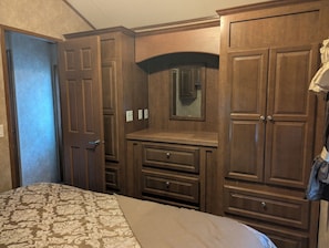 Une chambre à coucher avec un lit, une armoire en bois et une commode.