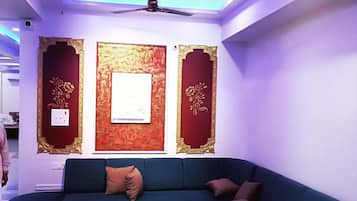 A modern living room with a dark blue sofa, a coffee table, and decorative wall panels.