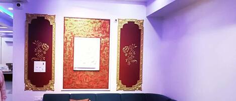 Una sala de estar moderna con un sofá azul oscuro, una mesa de centro y paneles decorativos en la pared.