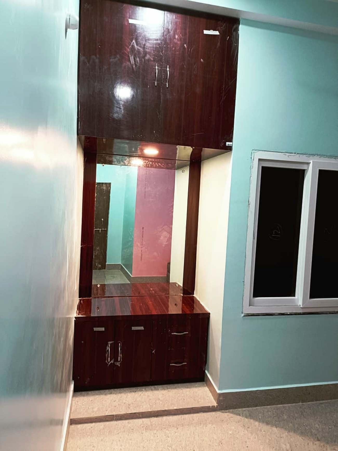 Una habitación con un armario grande, una ventana y un espejo que refleja el interior.