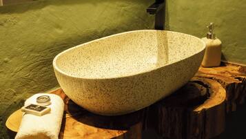 A spa bathroom with a large, speckled basin, a green towel, and a soap dish.