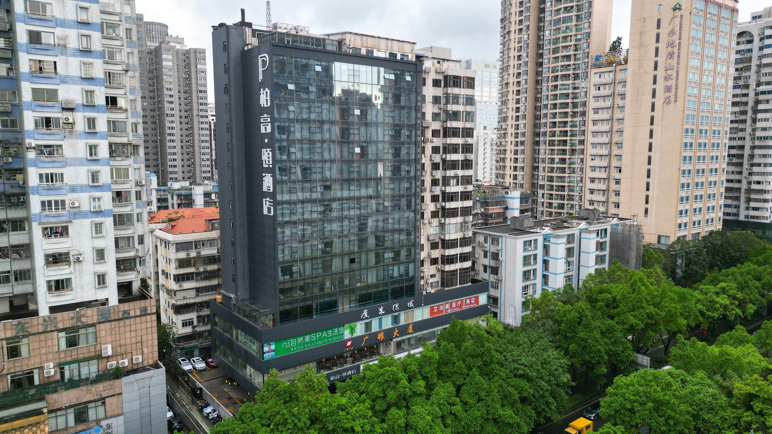 Un immeuble de grande hauteur, doté de nombreux étages, de grandes fenêtres et d’un rez-de-chaussée commercial avec une enseigne.